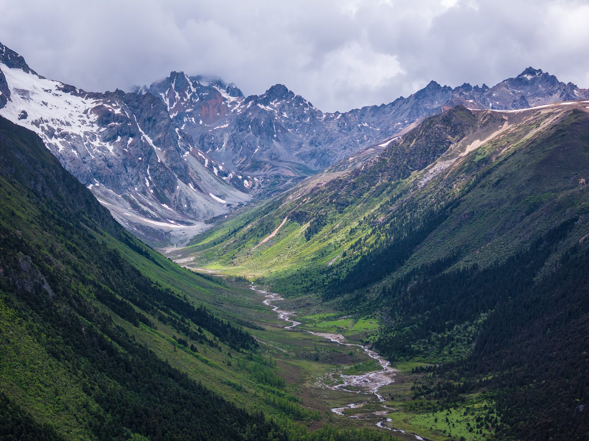 Beautiful aerial view of a lush green U-shaped river valley among vibrant mountains, promoting the scenic landscapes of North-East India