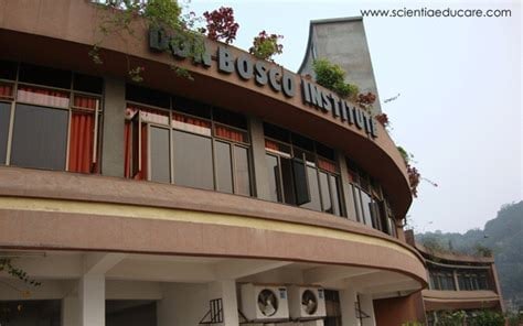 Curved modernist building with Bloom Institute signage, featuring horizontal windows and potted plants on the roof