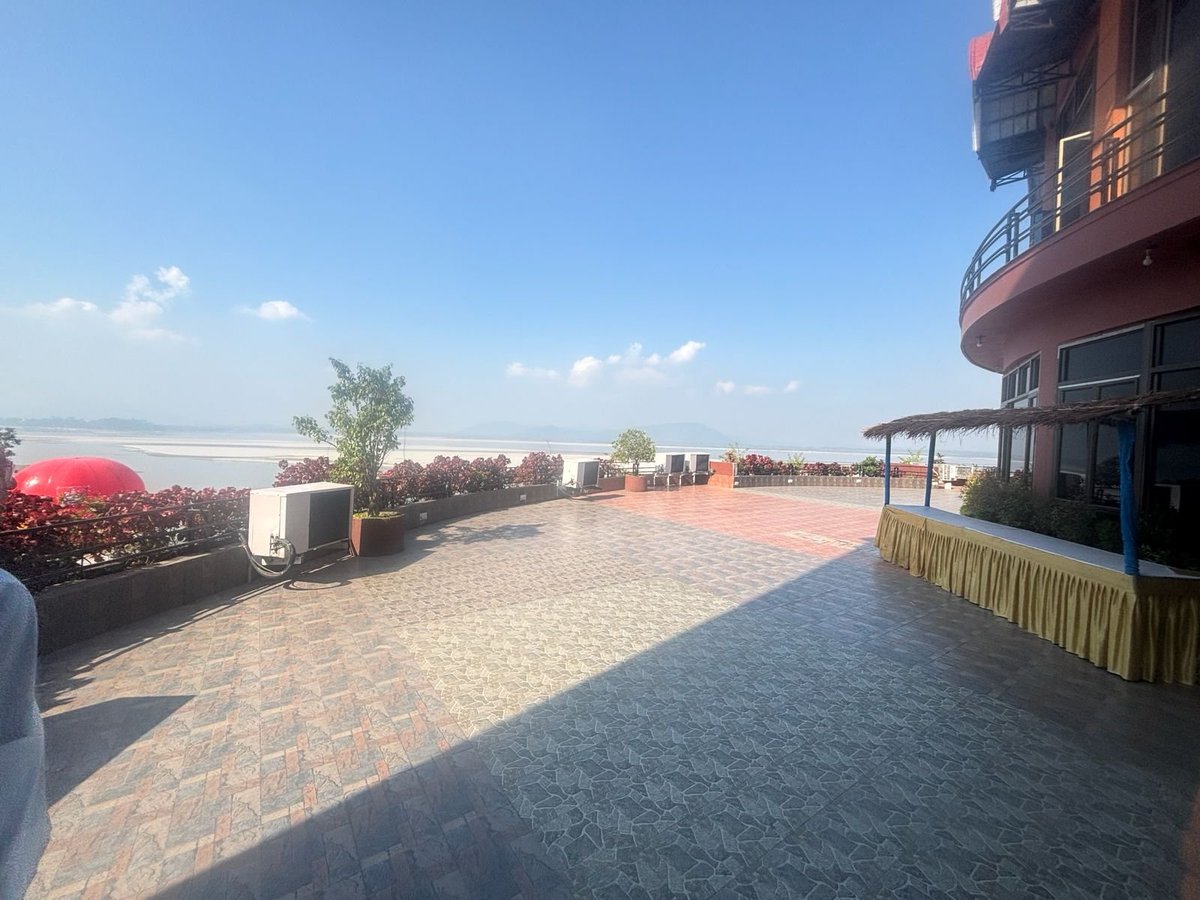 Expansive rooftop venue with brick paving, city skyline views, modern building structure, and outdoor event setup under blue sky
