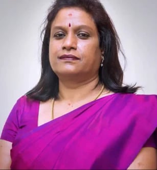 Woman wearing a bright magenta saree, looking at camera with a neutral expression against a white background
