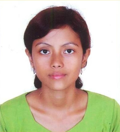 Portrait of a young woman with dark hair wearing a bright green v-neck shirt against a white background