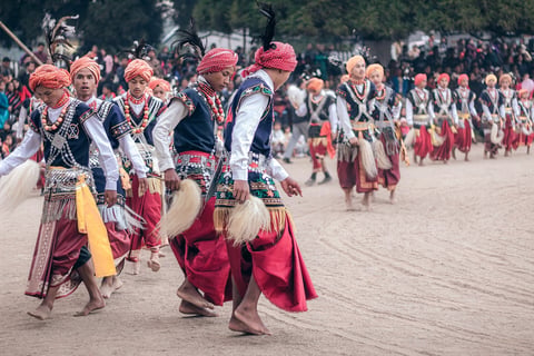 Group of people in traditional cultural clothing and headdresses participating in a street parade or festival celebration